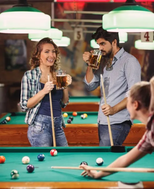 Group playing pool with drinks